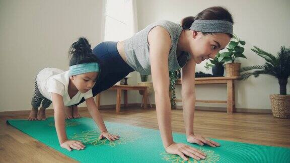 妈妈和小女儿在家里做瑜伽