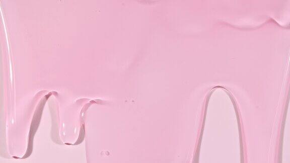 粉红色透明化妆品凝胶液与分子泡沫流动在平原白色表面微距镜头
