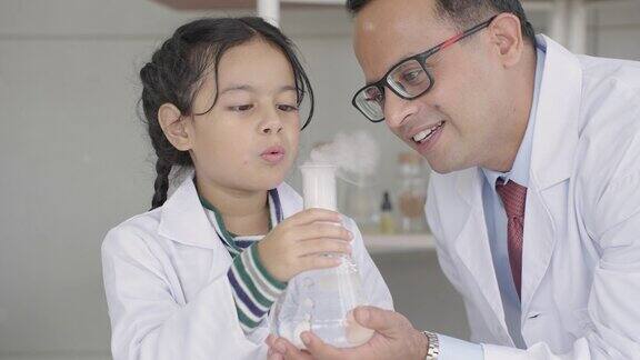在一间科学教室里印度的学生、孩子和老师被冰与水反应产生的烟雾吓得发抖吹着烟玩得开心