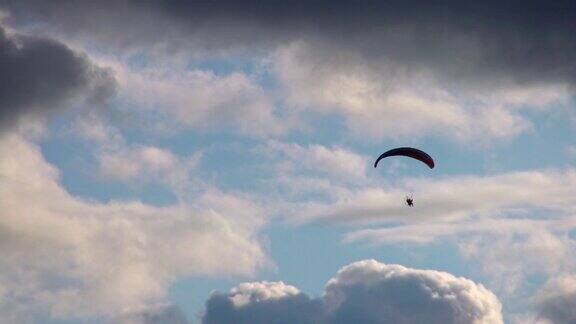 带马达的滑翔伞在蓝天上飞行