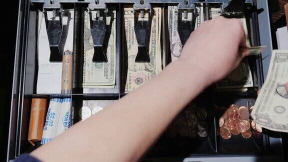 视频:一名女收银员用现金和现金工作只有手在画面中可见