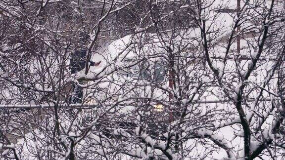 司机把车从被雪覆盖的树后面的雪地上挪开