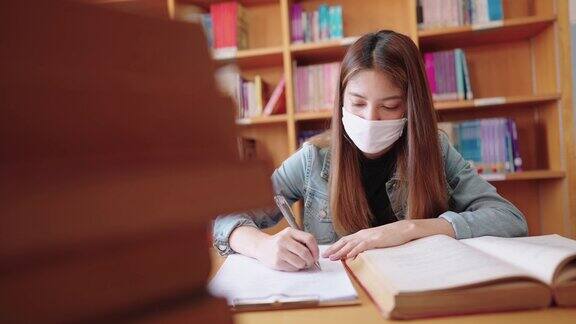 女大学生在大学图书馆看书和写书