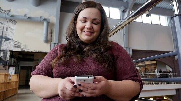 Body-Positive女性咖啡馆里拿着智能手机的漂亮女孩