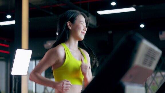亚洲年轻女子在健身中心的跑步机上进行有氧运动