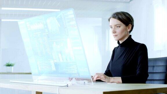 在未来的实验室美丽的女性计算机科学家在透明的计算机显示器上工作屏幕显示交互式用户界面与神经网络人工智能原型