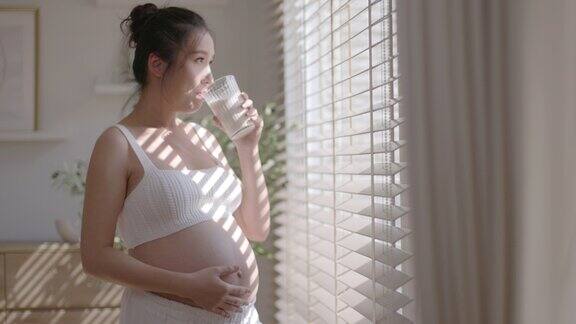 一位亚洲母亲喝鲜奶为未出生的孩子滋养子宫
