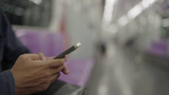 一名男子在乘坐电动火车通勤时上网发短信