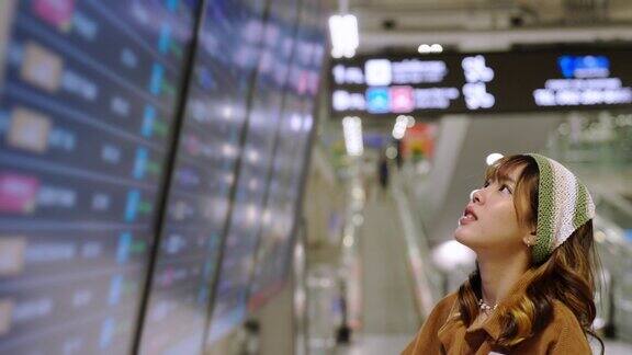 在机场候机楼查看航班时刻表的4K亚洲女性