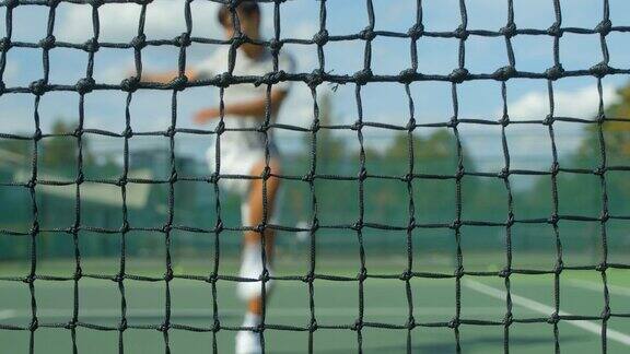 网球运动员把球击入网中把球拍扔到地上然后踢向空中