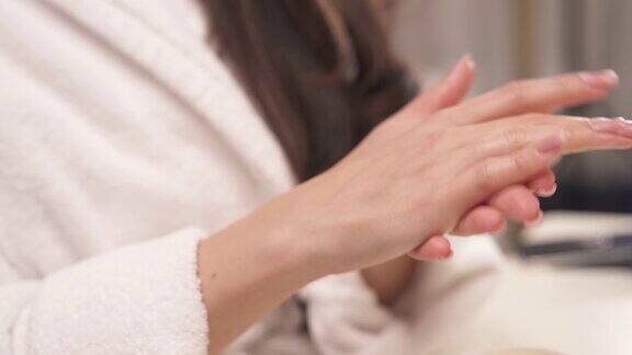一个女人的手平滑移动的特写将涂过的保湿护手霜涂抹使其浸透