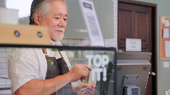 快乐的亚洲资深男性老板站在咖啡店技术创业退休愿景成功创新机会小型企业老龄化智慧独立协作领导服务资深企业家