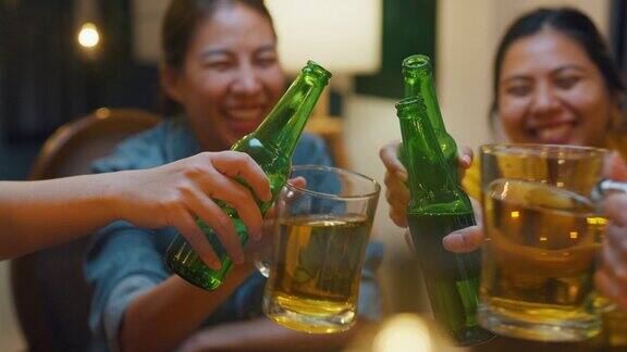 特写一群多民族的亚洲成年人朋友喝着酒啤酒瓶玻璃有有趣的笑声享受聚会在夜生活的室内家庭