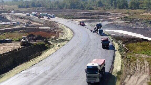 鸟瞰图:在道路建设中制造新的沥青摊铺机或摊铺机铺沥青辊子平整和致密的新沥青路面修复新路建设Tilt-shift效应