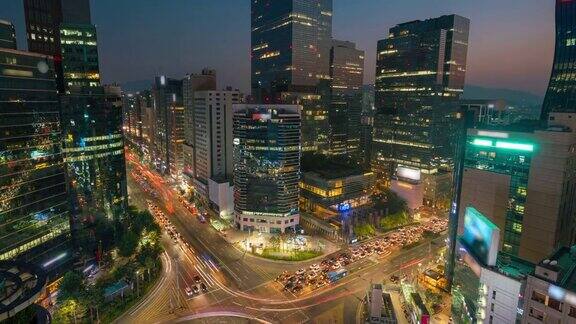 在韩国首尔市的首尔江南中心商业区的一个十字路口从白天到晚上的光线轨迹交通速度