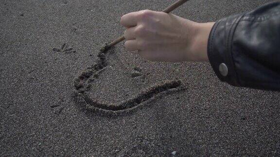 沙滩上的女孩在沙滩上画了一颗心女孩在沙滩上画心形符号