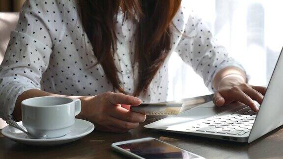 年轻女子用信用卡在网上购物网上购物付款