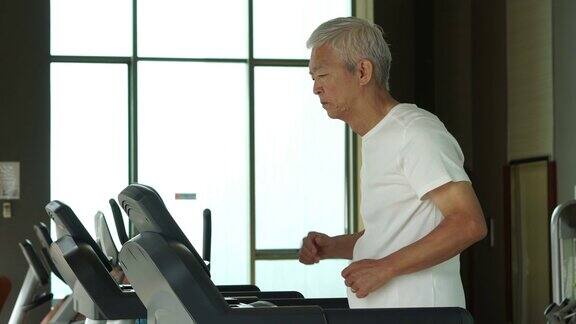 亚洲老年人在健身房的跑步机上跑步锻炼健康的生活方式