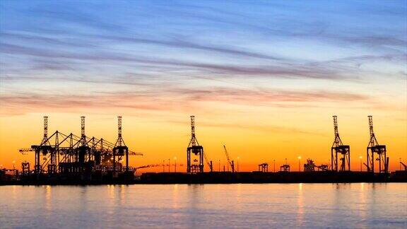 集装箱港口码头附近的海滩夕阳与戏剧性的彩色天空从白天到夜晚的时间流逝