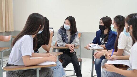 女大学生在“社交距离”教室里间隔着座位以防止传染性疾病