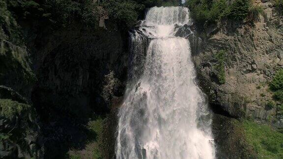 壮观的瀑布空中飞行下峡谷悬崖与水溅在慢动作