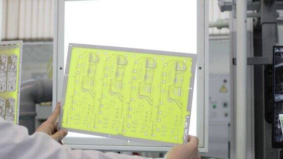专家在实验室检查电子电路板的手的特写视觉检查