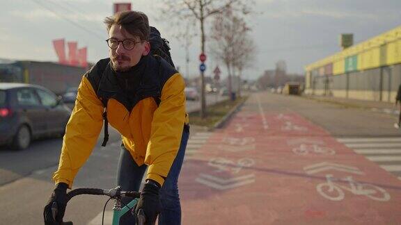 一个穿黄色夹克的年轻人骑着自行车在自行车道上骑车