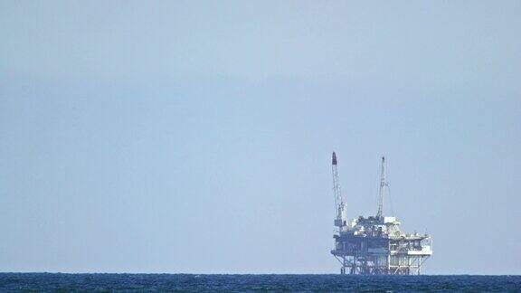 慢镜头拍摄的一个近海石油钻井平台亨廷顿海滩附近的海岸南加州
