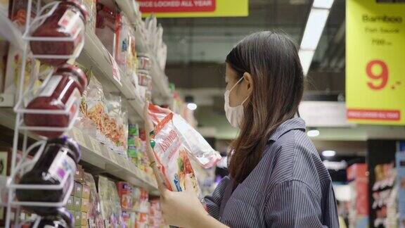 亚洲妇女在杂货店挑选食物