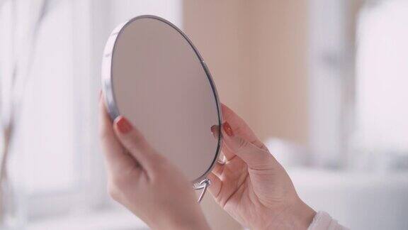 女性手握镜子的特写美容程序美容
