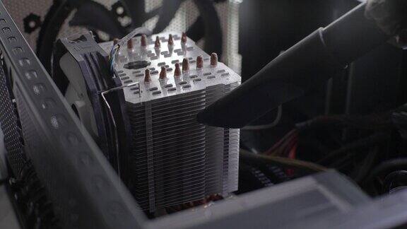 极度特写不认识的电脑师傅男性正在用吸尘器从台式电脑处理器冷却系统的散热器上清除灰尘