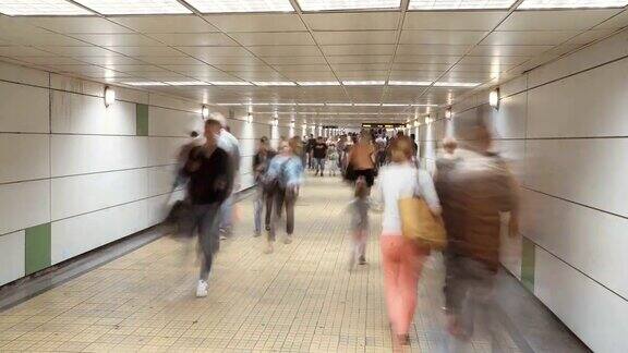 人们在繁忙的地铁站登上火车和乘坐自动扶梯的时间流逝