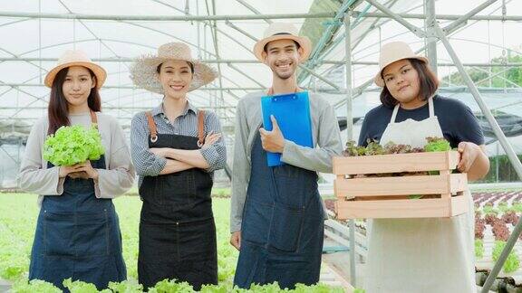 肖像组亚洲农民工人在蔬菜水培农场有魅力的年轻农家男女在温室工作后自豪而自信幸福地看着镜头