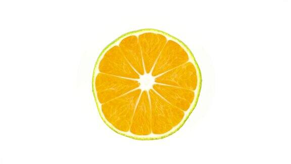 一个绿色橘子的横截面在转盘上旋转孤立在白色背景上特写镜头宏
