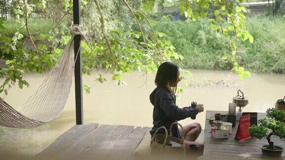 年轻女子坐在外面她准备在木桌上煮咖啡