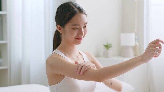 年轻的亚洲美女使用身体乳液和护肤霜亚洲美容皮肤