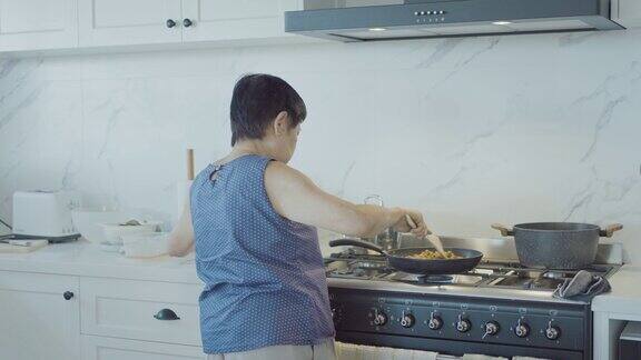 亚洲老年妇女在家做饭活跃老年退休生活