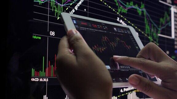 商人在智能手机和电脑上分析股票市场数据