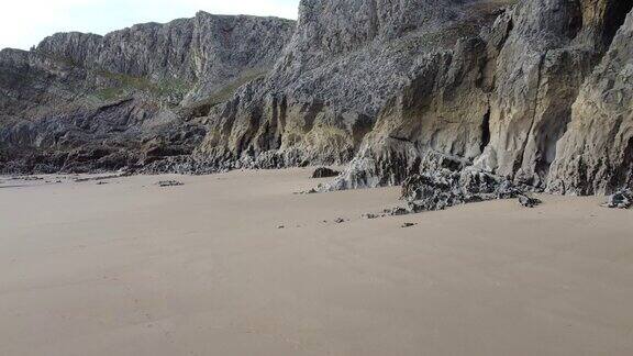沙滩上有锯齿状的岩石和小海洞-无人机拍摄4K