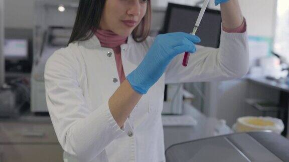 女医学研究科学家在应用科学实验室的数字显微镜下分析生物样本前观察白大褂实验室工程师致力于疫苗和药物研究