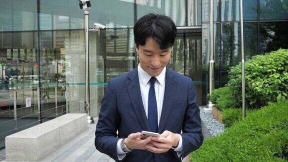 成年韩国商人在办公大楼附近使用手机在冠状病毒封锁后回到办公室