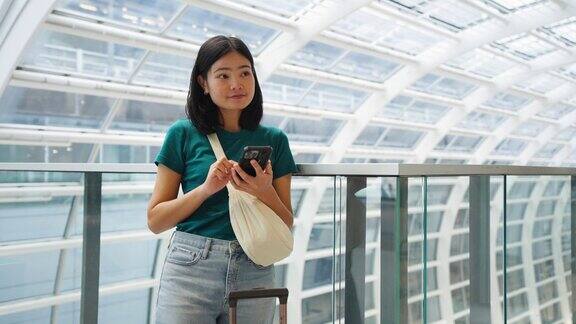 玩手机通讯在候机楼内等候登机的女子旅行