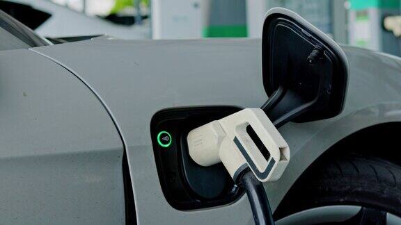 在停车场或加油站为车辆充电电动汽车充电站纯能源是环保的未来世界