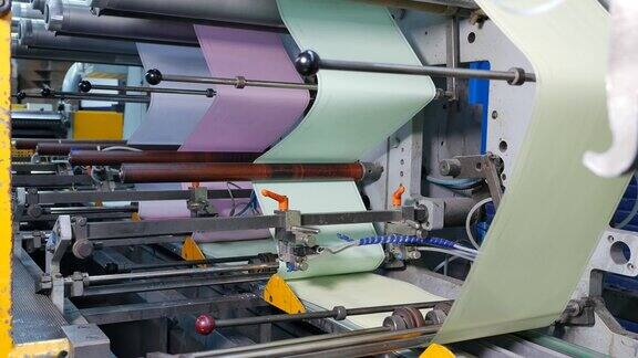 信封厂装配线上的蓝色、粉色、绿色和黄色纸张