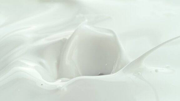 巧克力块落入奶油牛奶在微距和慢镜头飞溅