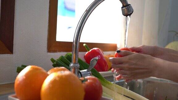 在厨房里洗水果或蔬菜的女人