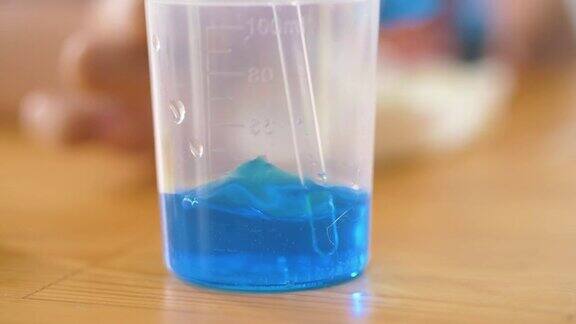 在烧杯中搅拌蓝色进行科学实验