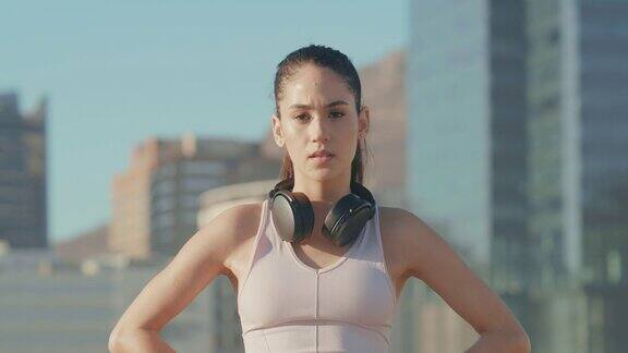 一段4k视频一名年轻的运动女性在城市中锻炼时脖子上戴着耳机