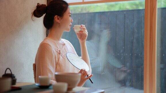 年轻女子喝着一杯中国茶