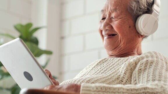 亚洲老年妇女在家中使用平板电脑搜索冠状病毒或Covid-19病毒信息以预防疫情高级技术、老年人、退休、生活方式、医疗保健和医疗、东南亚和东亚:50岁以上人群、冠状病毒或Covid-19